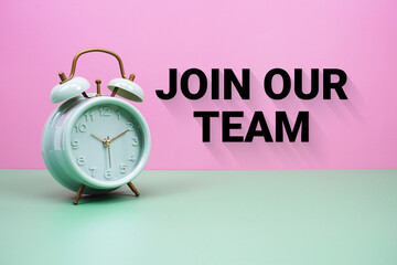 Black alarm clock on a pastel green and pink background with the text 