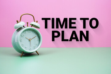 Black alarm clock on a pastel green and pink background with the text 