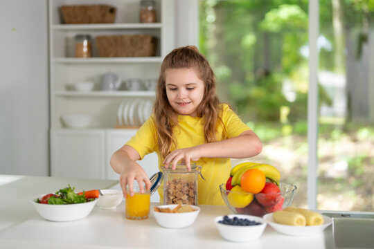 Kid eating healthy breakfast at home. Kid enjoying fresh fruits at the dining table. Happy kid having tasty lunch in the kitchen. Child during family meal. Young kid eat dinner.