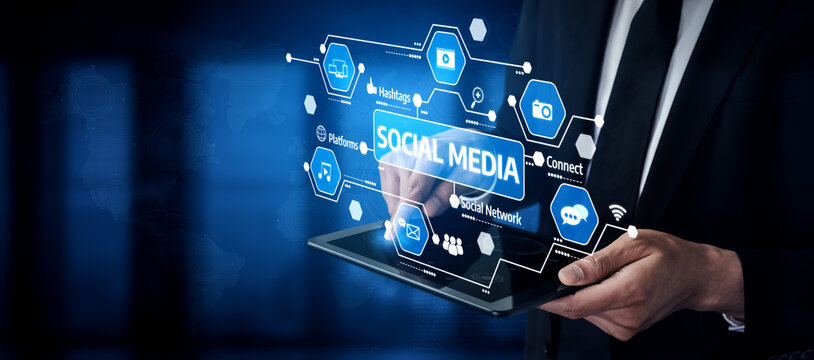 A businessman engages with a tablet showcasing digital icons related to social media and networking, set against a modern office backdrop, illustrating digital communication trends. Tessel