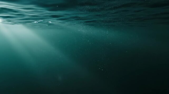 Sunlight penetrates the deep blue ocean creating an ethereal underwater scene.