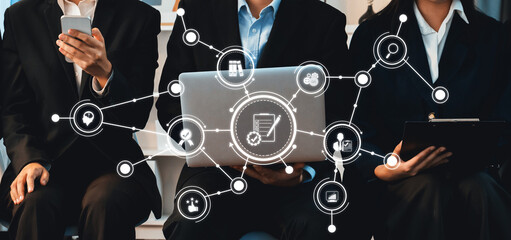 Asian job applicant in identical formal wear sitting in waiting room for job interview. Office worker or business people working in cramped room together using laptop and phone. Trailblazing Amity