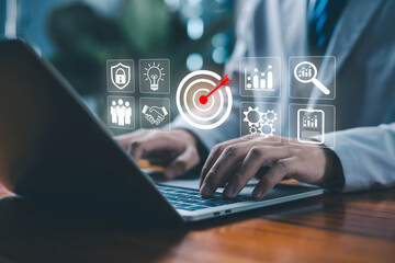 A business professional using a laptop with digital icons of target, analytics teamwork ideas, and security symbolizing strategic planning, KPI management, goal achievement, data analysis, and modern.