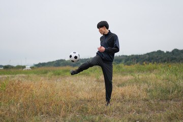 サッカーのリフティングの練習をする男性 © monzenmachi