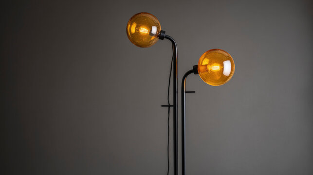 A pair of yellow lamps with black bases sit on a grey surface