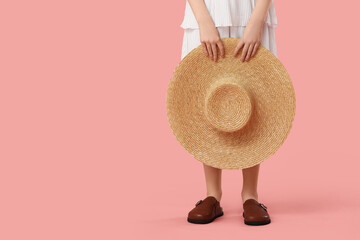 Teenage girl in clogs with hat on pink background