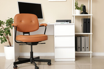 Interior of office with workplace, shelving unit and chair