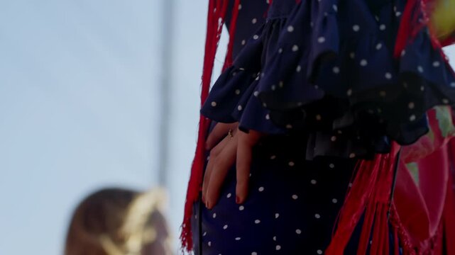 Vibrant red flamenco dress with playful fringes glowing under the afternoon sun at Seville's April Fair