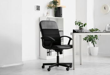 Comfortable workplace with black chair in interior of room, closeup