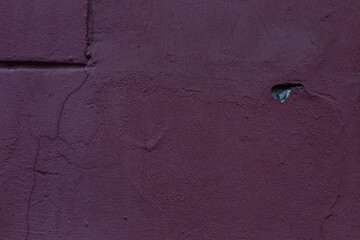 An old burgundy concrete wall of a house. Construction and renovation. Background. Space for text.