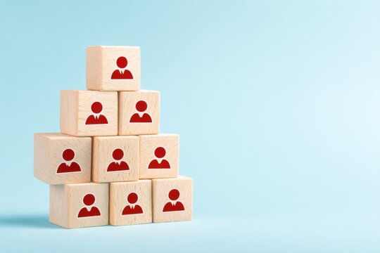 Pyramid of People: A symbolic pyramid is constructed using wooden blocks, each bearing the icon of an individual, representing the concepts of team, hierarchy, and organizational structure. 