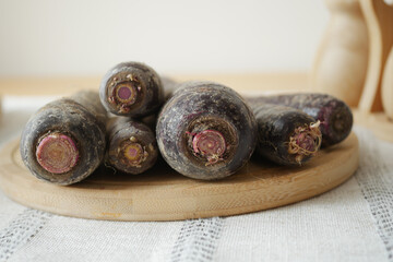 Fresh black carrots on a wooden cutting board