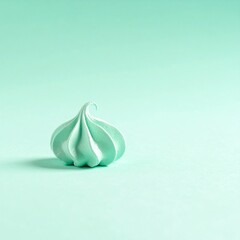 パステルミントの背景に、小さなメレンゲクッキーを一つだけ置いたミニマルで清涼感のある写真です。
ふわっとした柔らかな光がメレンゲの軽さと優しい白さを引き立てます。
