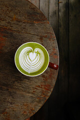 A cup of green tea matcha latte on wooden background           
