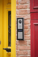 Modern intercom system mounted on a colorful brick wall