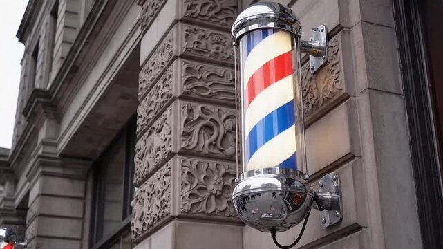Illuminated barber pole with red white and blue stripes attached to building exterior
