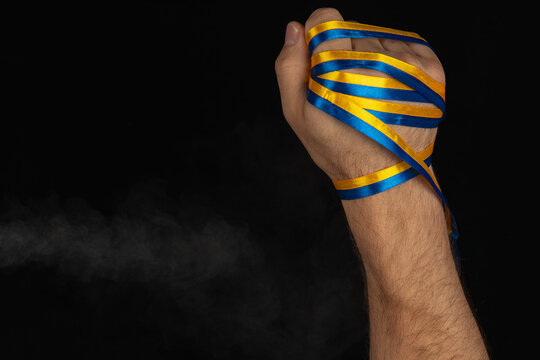 Fist wrapped in blue and yellow ribbons represents strength and unity