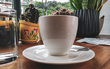 Glass cup of americano black coffee with spoon and plate.