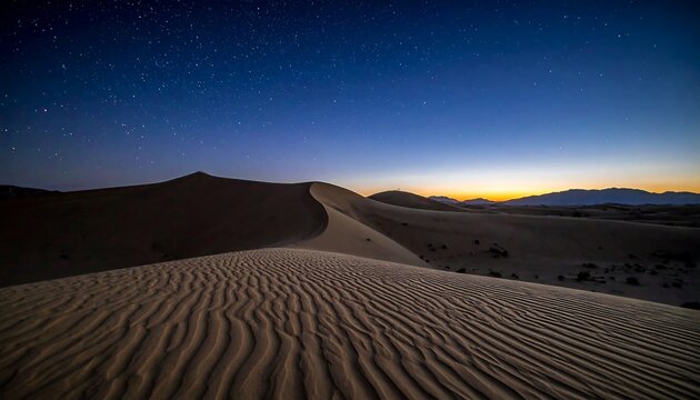 A serene desert scene under a starlit night sky, with undulating sand dunes in the foreground and mountains in distance