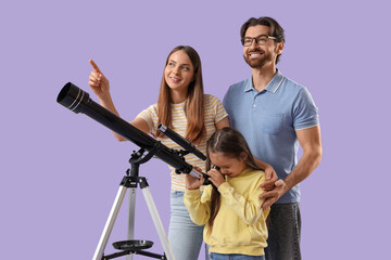 Fototapeta premium Little girl with her parents looking through telescope on lilac background