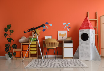 Fototapeta premium Interior of stylish children's room with cardboard rocket, table, toys and modern telescope