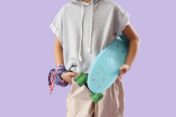 Little boy with skateboard on lilac background © Pixel-Shot