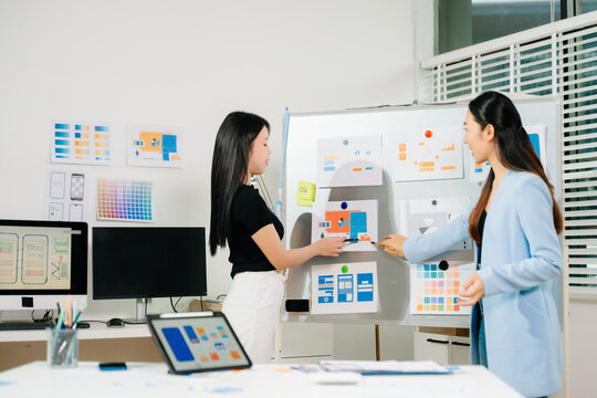 UX UI designers presenting mobile app wireframes and color palettes during a creative startup meeting, showcasing collaboration, planning, and modern design workflow. - Powered by Adobe