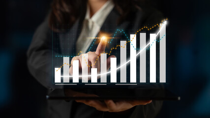 A business professional reviews data trends on a tablet, highlighting financial growth and strategic insights in a contemporary corporate environment. Impute