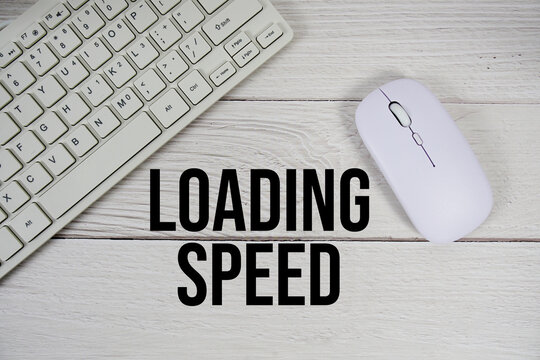 Loading Speed text with keyboard and wireless mouse on wooden background