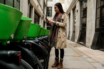 Woman using smartphone to unlock city shared bike