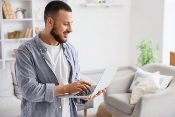 Young man using laptop to search online at home