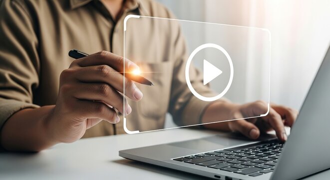 A person using a stylus to interact with a virtual play button interface on a laptop, representing video content creation, online streaming, and digital media