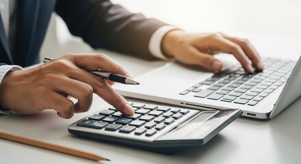 Accountant using calculator and laptop for financial analysis and business planning, closeup view of hands at desk