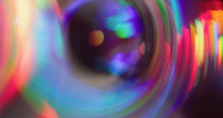 Bokeh round prism. Holographic glow leak. Spectrum color twinkle on night background. Purple red green neon whirl blur abstract flash.