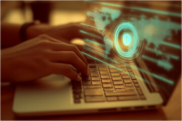 A person is typing on a laptop, displaying a digital interface with a globe and security features, representing technology and cybersecurity.