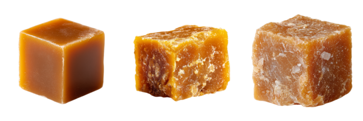 Three blocks of unrefined cane sugar in varying textures and shades of brown isolated on a transparent background