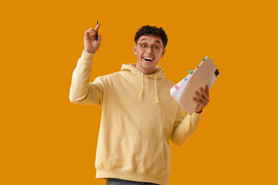 Happy male screenwriter with scenario on yellow background
