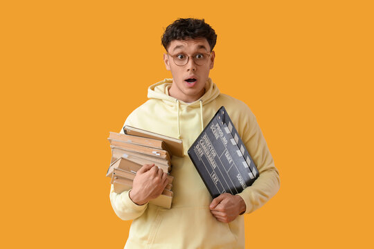 Shocked male screenwriter with books and movie clapper on yellow background