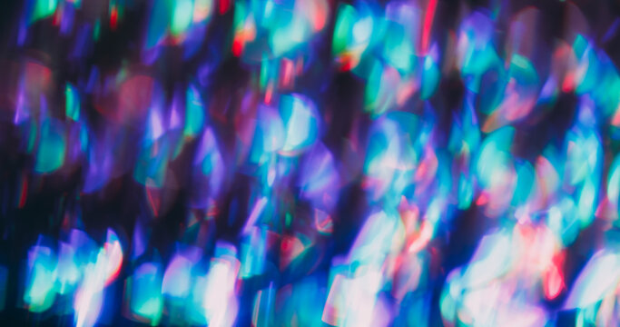 Prism bokeh lens. Leak illumination. Neon colorful shimmering bright kaleidoscope effect. Purple red green abstract blur art background.