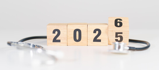 2025 end year to Happy New Year 2026 with Stethoscope of doctor and heart shape on table. health care, Insurance, Wellness and medical concepts