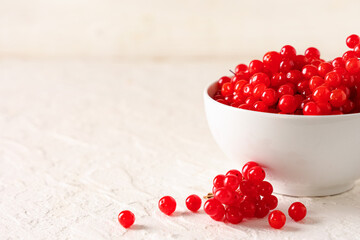 Bowl with fresh viburnum berries on white background