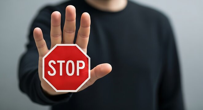 Hand holding red stop sign white octagonal - Powered by Adobe