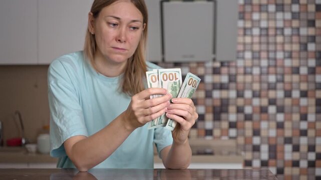 A concerned woman sits at her kitchen table, counting cash as she faces the stress of rising utility bills. She reflects on her finances while feeling overwhelmed and anxious.