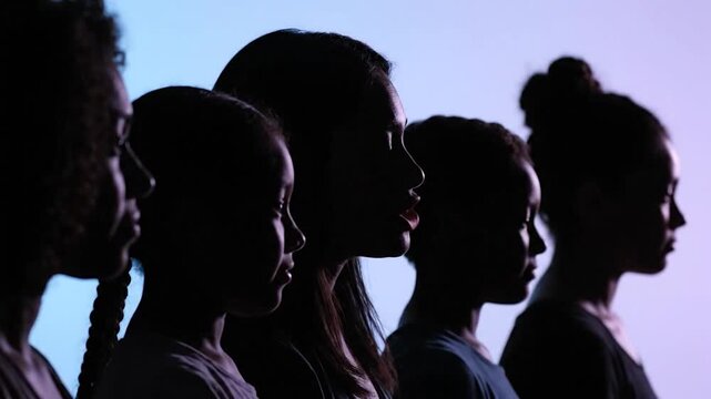 Silhouette profiles of five women of different ages, lit against a gradient backdrop