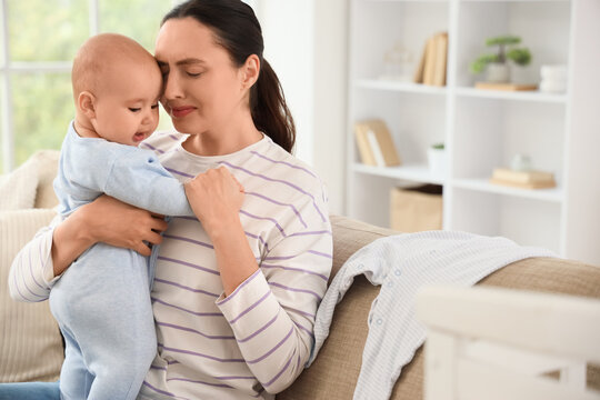 Crying mother with her baby suffering from postnatal depression at home