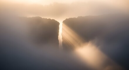 Sun rays breaking through the clouds over a mountain landscape creating a dramatic and serene atmosphere during sunrise or sunset
