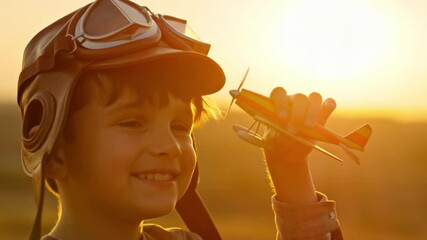 A Young boy with aviator cap, smiling cheerfully and holding a model airplane Stock Video