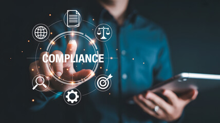 Person interacting with compliance icons in a digital interface holding a tablet device in hand