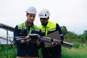 Two men in construction gear are looking at a drone