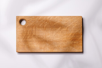 Empty cutting board on a white background with leaf shadows